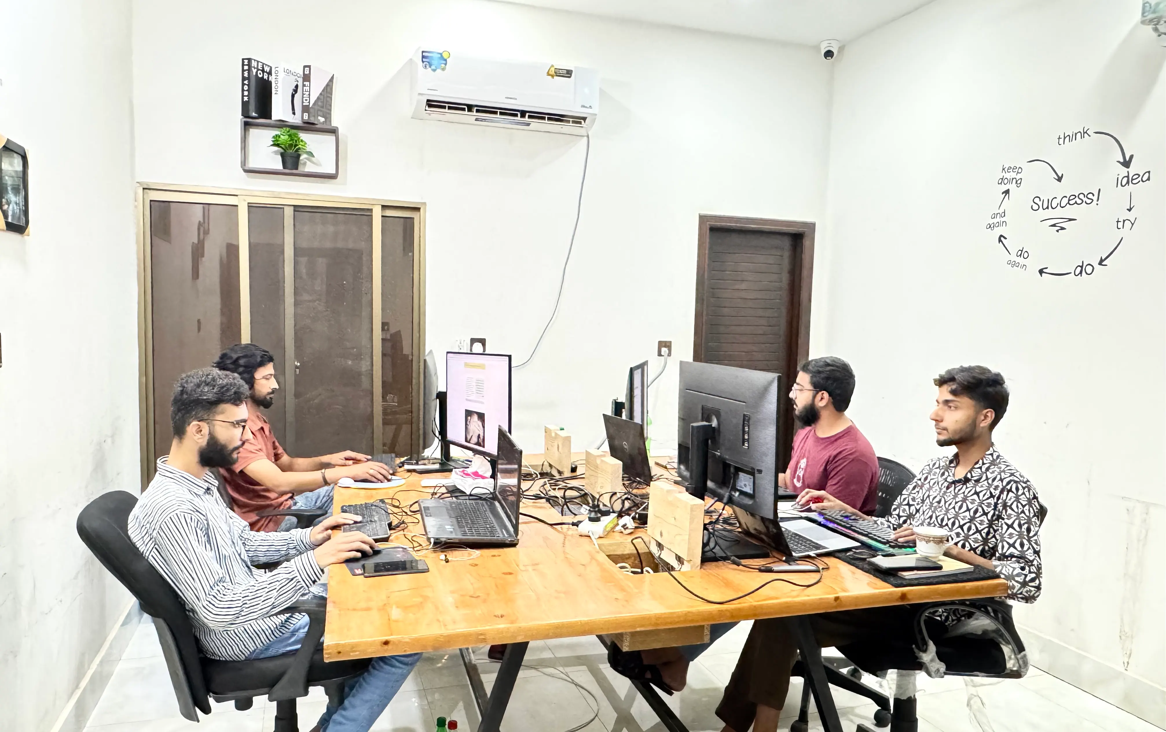 Dev Entity software team collaborating around office workstations